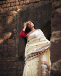 Woman wearing ivory pure silk hand printed saree in festive editorial pose
