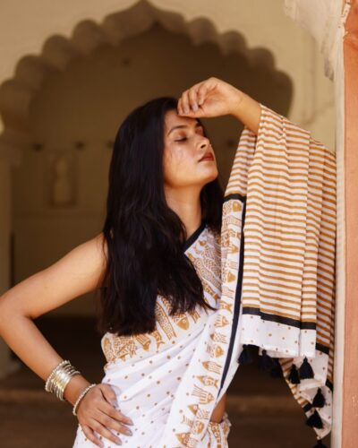 Woman wearing white mustard hand block print mul cotton saree