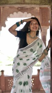 Model wearing hand block printed mul cotton saree with green floral design showing drape and fit