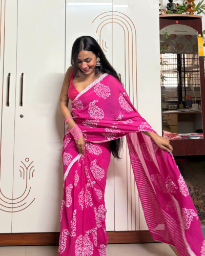 Pink georgette printed saree with white floral motifs and striped pallu