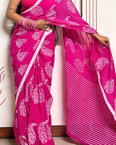Pink georgette saree with white printed motifs and striped pallu