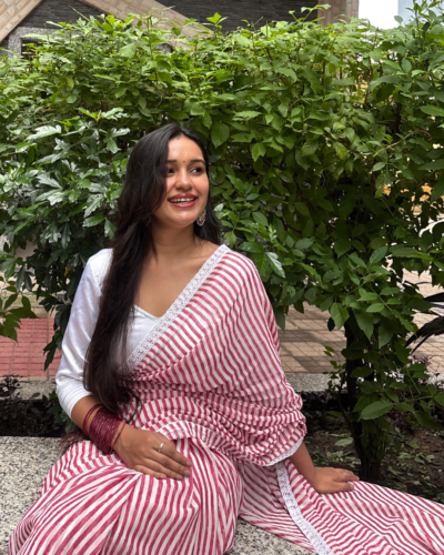 Pink and white striped Georgette saree worn by a woman